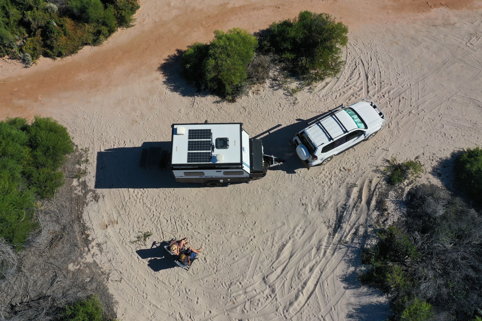 Caravan parked at a sandy campsite